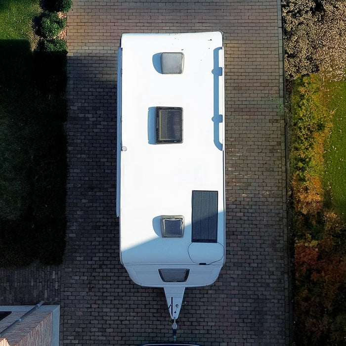 Birds eye view of a Mestic solar panel mounted on a caravan roof on a driveway