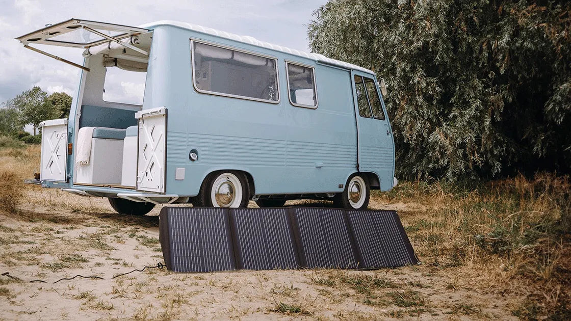 Mestic foldable solar panel set up on a beach in front of a campervan — portable off-grid power