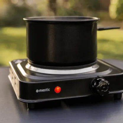 Single-burner Mestic cooker in use on a camping table — quick meals on the road