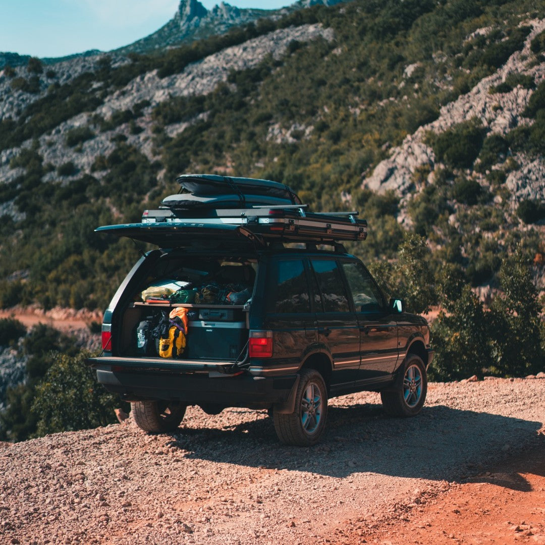 Off-road camping vehicle with a Mestic cool box and roof tent ready for the wild