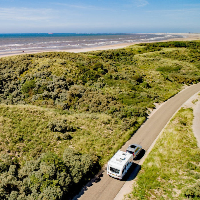 Coastal caravan trip with a Mestic white rooftop air conditioner ready for warm weather