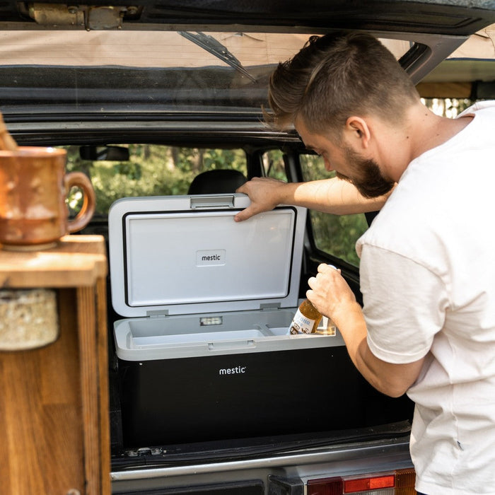 Person reaching into a Mestic split compartment cool box with dual temperature zones
