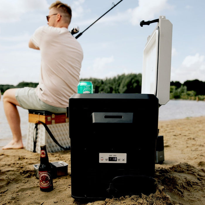 Mestic compressor cool box on a fishing trip with an angler casting in the sunshine
